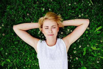 image of relaxed woman laying in the grass