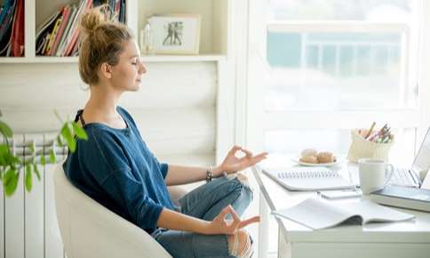 Woman meditating in home office space