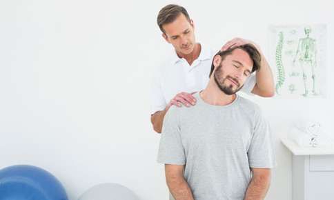 A picture of a chiropractor giving a patient an adjustment by tilting the patient's head and apply pressure to his shoulder.  